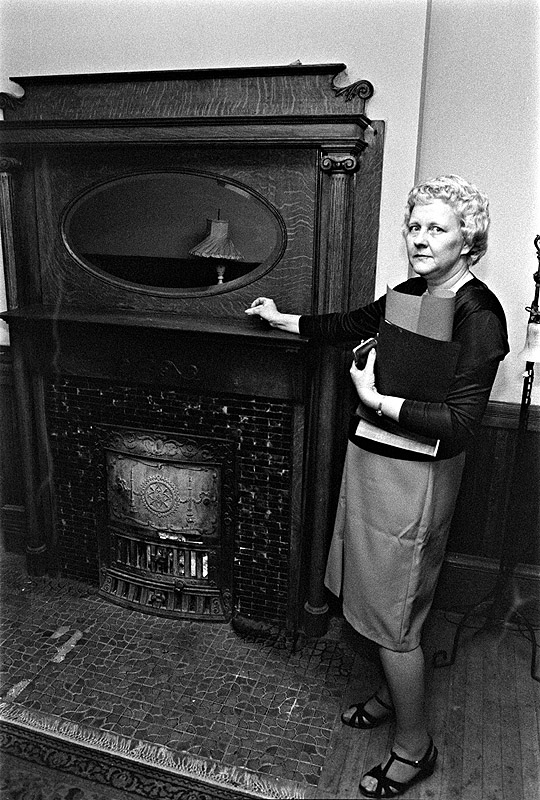 [ WOMAN POINTING TO FIREPLACE AND MIRROR ]